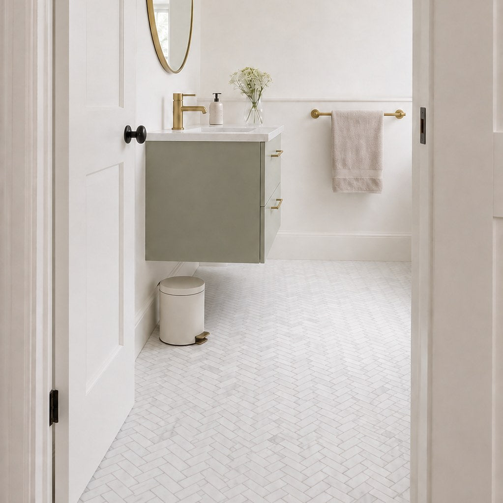 Carrara Petite Herringbone Mosaic Tile as a bathroom floor seen from the doorway. Reference installation photographed by our supplier.