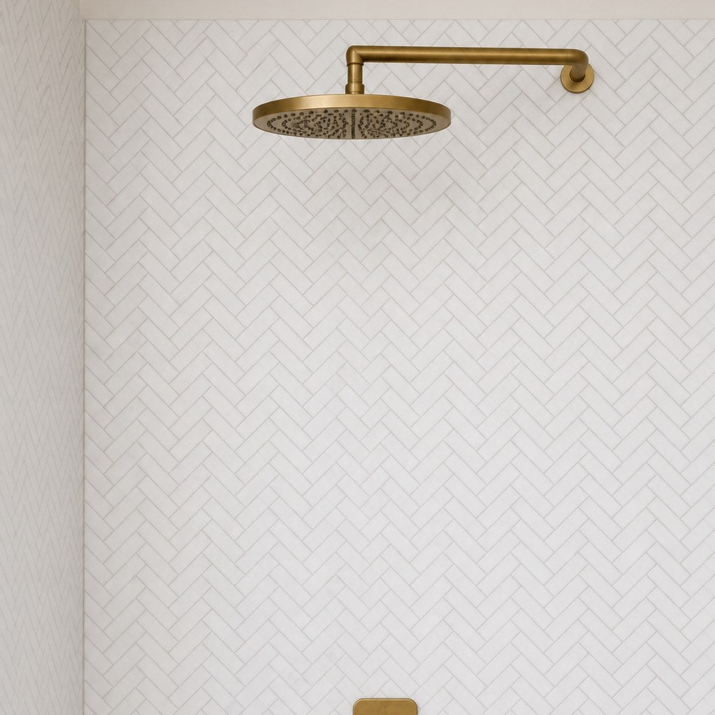 Carrara Petite Herringbone Mosaic Tile across two shower walls. Reference installation photographed by our supplier.