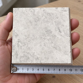 Atlas Pearl Stone-Look Tile sample held in a hand.