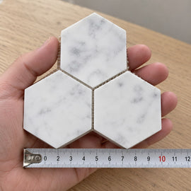 Carrara Large Hexagon Mosaic Tile sample held in a hand.