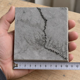 Coastal Stone Travertine-Look Tile sample held in a hand.