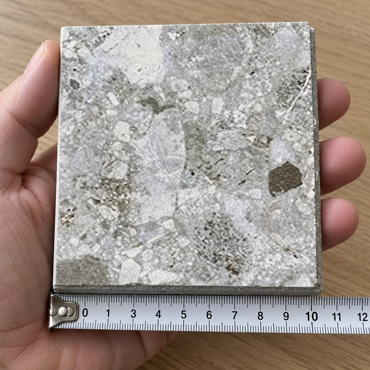 Haven Pebble In/Out Terrazzo-Look Tile sample held in a hand.