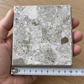 Haven Pebble In/Out Terrazzo-Look Tile sample held in a hand.