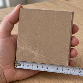 Pietra Sienna Marble-Look Tile sample held in a hand.