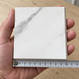 Pietra Vela Marble-Look Tile sample held in a hand.