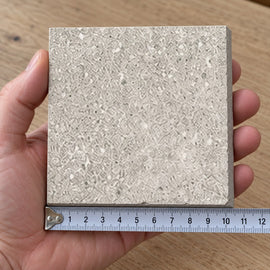 Quarry Ash Concrete-Look Tile sample held in a hand.