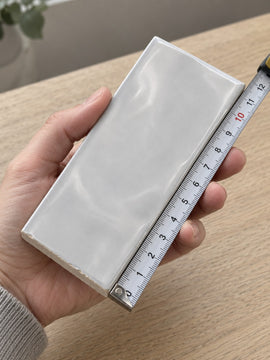 Studio Cloud Wave Subway Tile sample held in a hand.