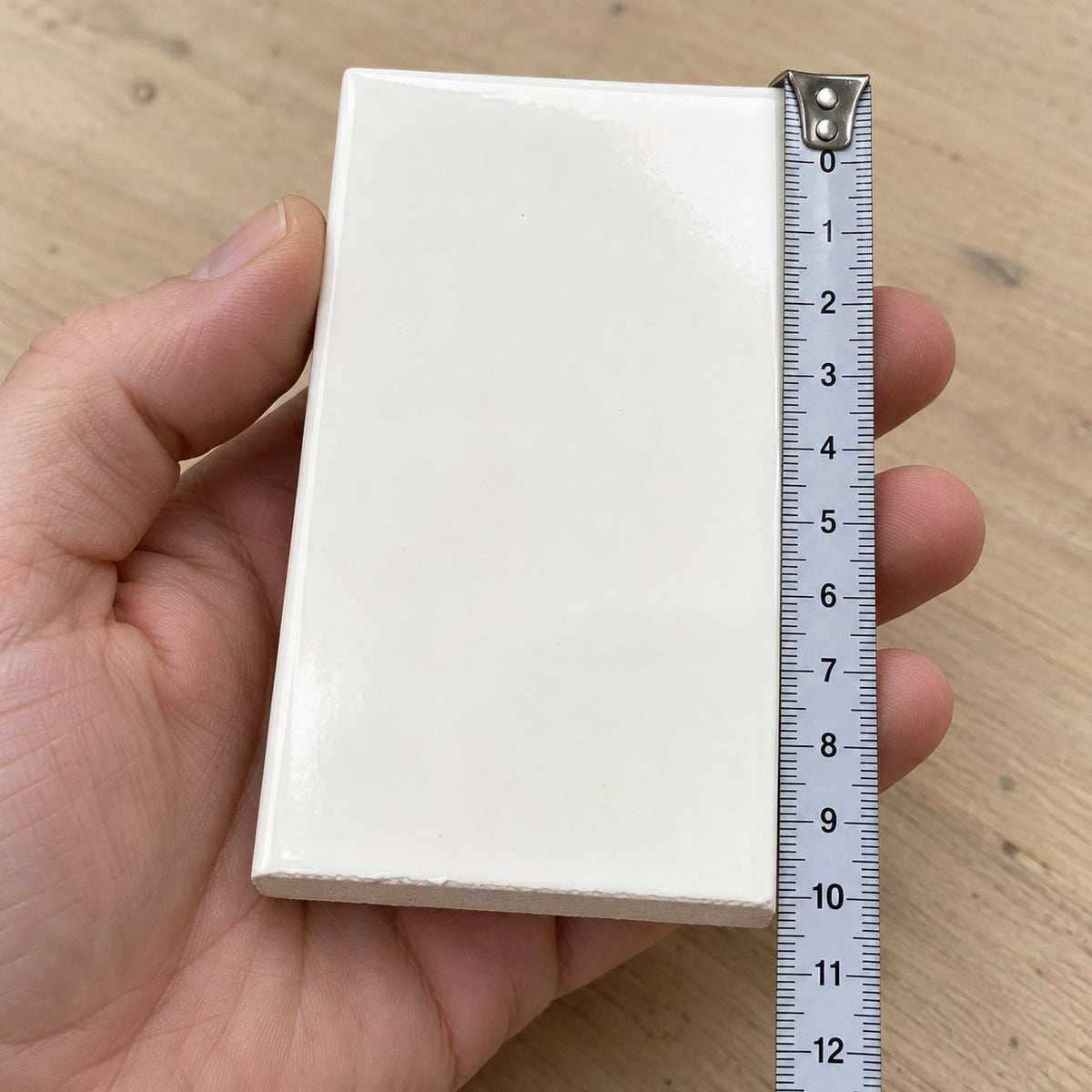 Studio Flat Subway Tile sample held in a hand.