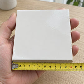 Studio Pure White Wall Tile sample held in a hand.