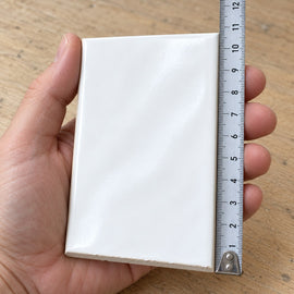 Studio Wave Subway Tile sample held in a hand.