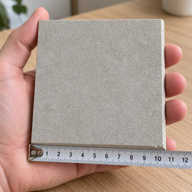 Urban Mist Concrete-Look Tile sample held in a hand.