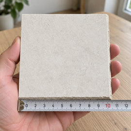 Urban Pearl Concrete-Look Tile sample held in a hand.
