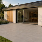 Urban Mist Concrete-Look Tile on a garden terrace outside a glazed extension. Reference installation photographed by our supplier.